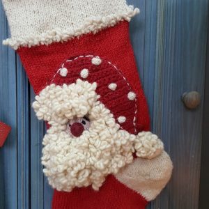 Detailed view of fluffy Santa Claus design on red and cream knit Personalized Christmas stocking.