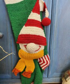 Close-up of elf appliqué on green knit Christmas stocking
