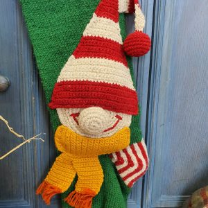 Close-up of elf appliqué on green knit Christmas stocking