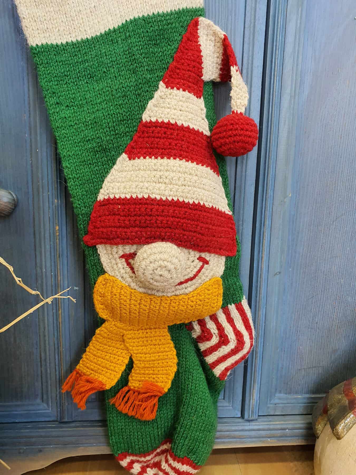 Close-up of elf appliqué on green knit Christmas stocking