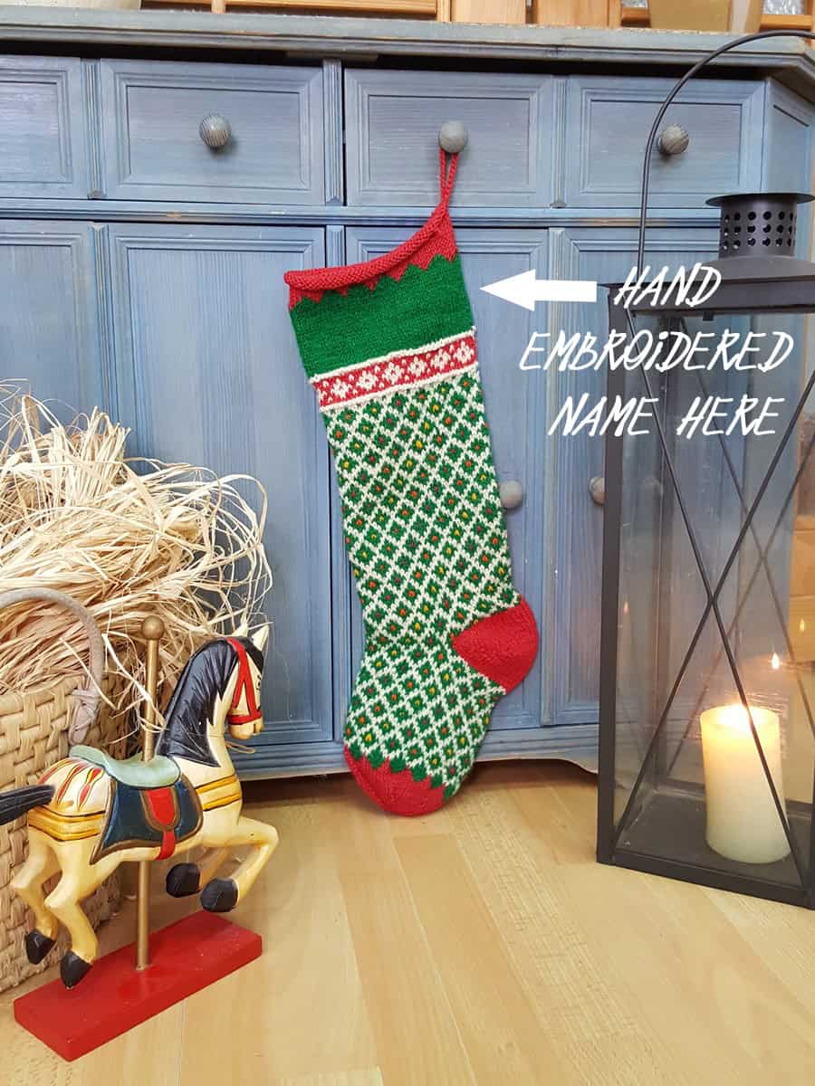 Personalized green knit Christmas stocking with red cuff and white diamond pattern, custom name on the cuff