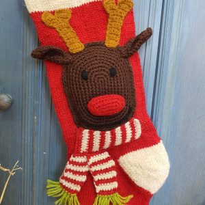 Close-up of Rudolph reindeer appliqué on hand-knit personalized Christmas stocking