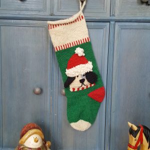 Personalized dog stocking hanging beside a lantern in a cozy scene