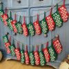 Hand-knit Christmas advent calendar garland of 24 mini stockings hanging on a wall
