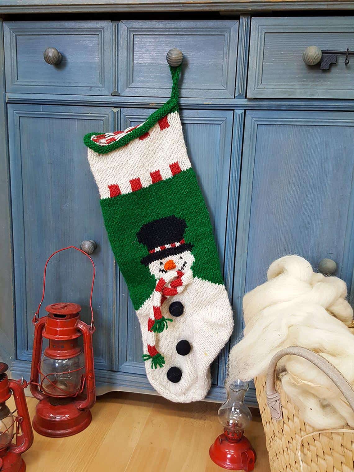 Fair-trade handmade holiday stocking featuring a smiling snowman with scarf and top hat.