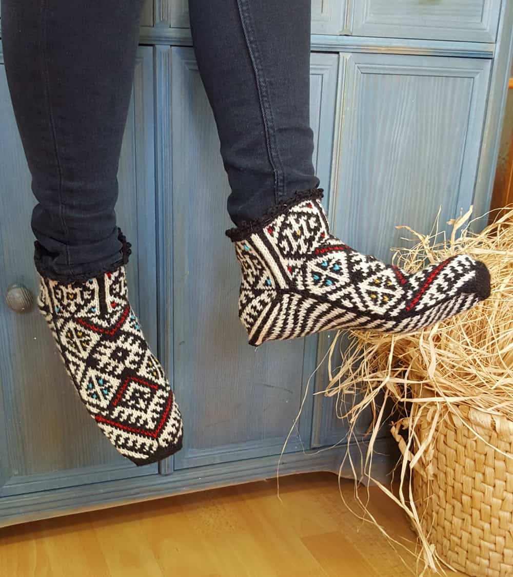Artisan wool slipper socks in black and white worn indoors