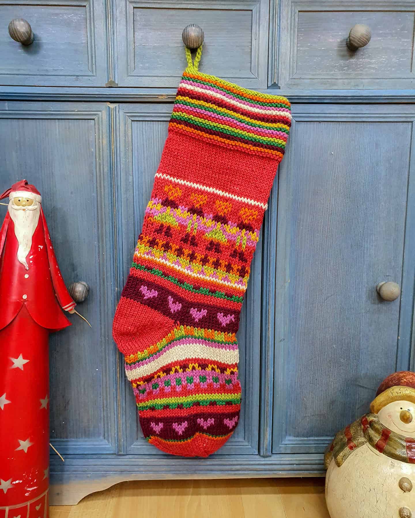 Fair Trade striped Christmas stocking with hearts in red, green, pink, and multicolor pattern - Artisan Holiday Decor.