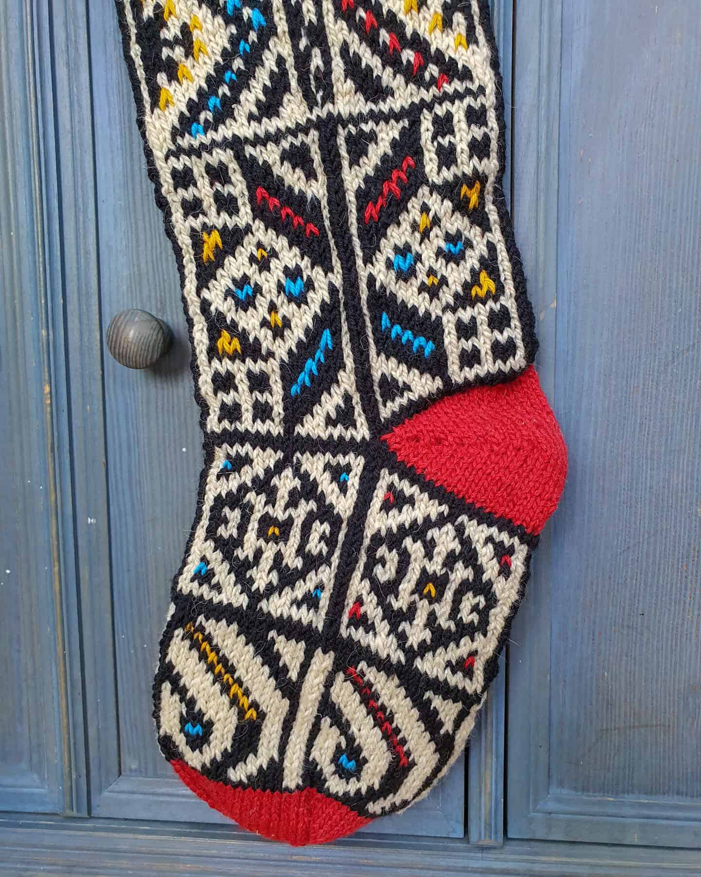 Close-up of red heel on personalized Christmas stocking with jacquard pattern.