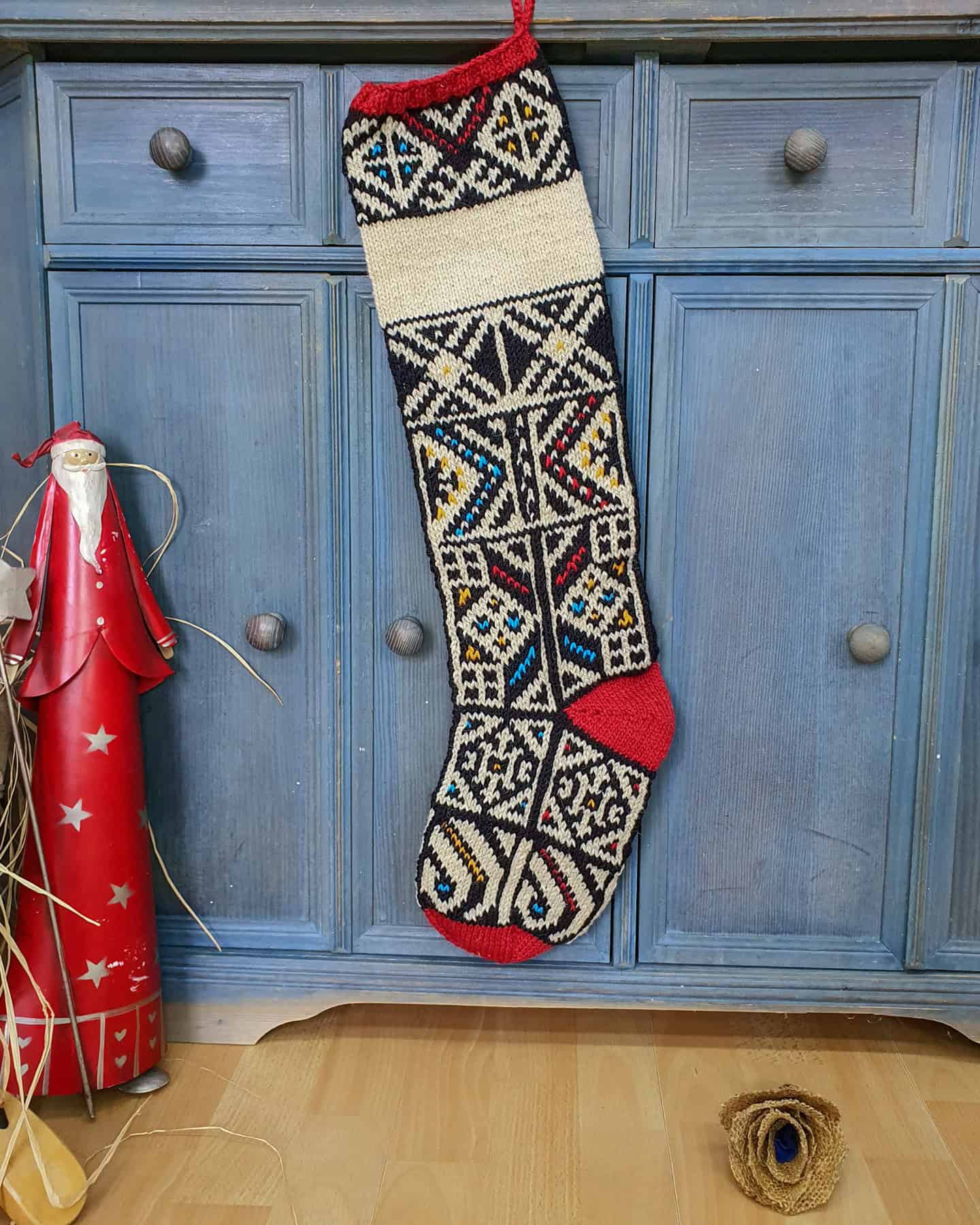Personalized hand-knitted Christmas stocking with Bosnian jacquard pattern and red heel and toe detailing.