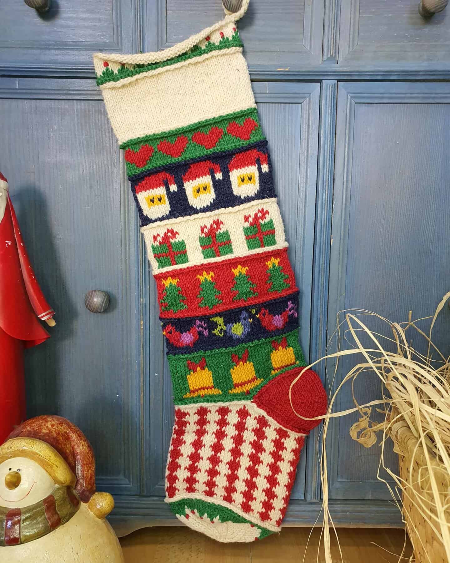 Full view of a personalized Christmas stocking hand-knitted with festive motifs.