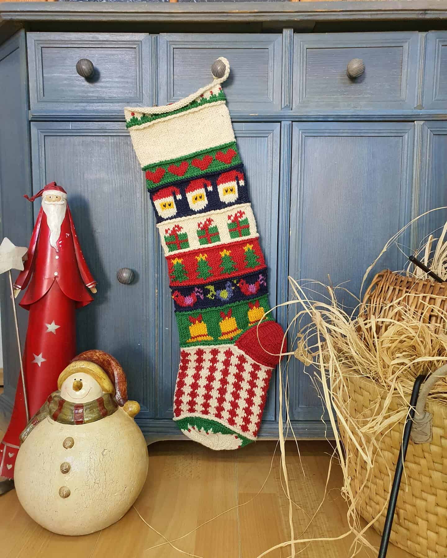 Personalized hand-knitted Christmas stocking with Santa and gift patterns.