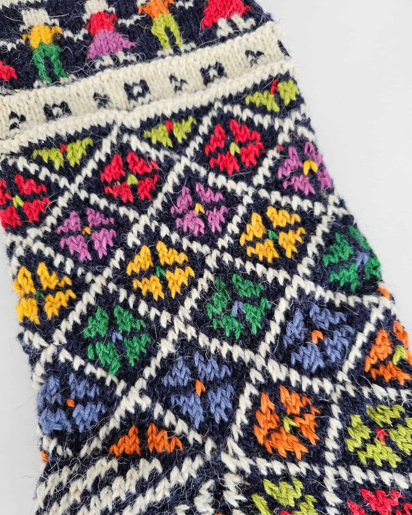 Close-up of a festive Christmas stocking showing intricate folk art patterns. Add a custom name for fee.