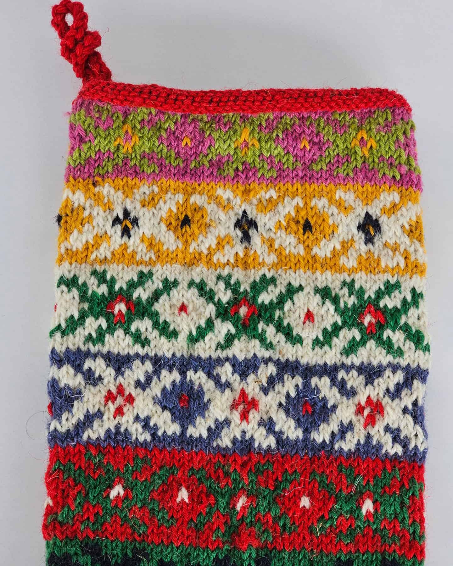 Close-up of colorful hand-knitted Christmas stocking with traditional patterns.