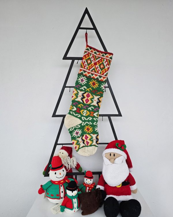 Christmas stocking with traditional pattern hanging on Christmas tree shape