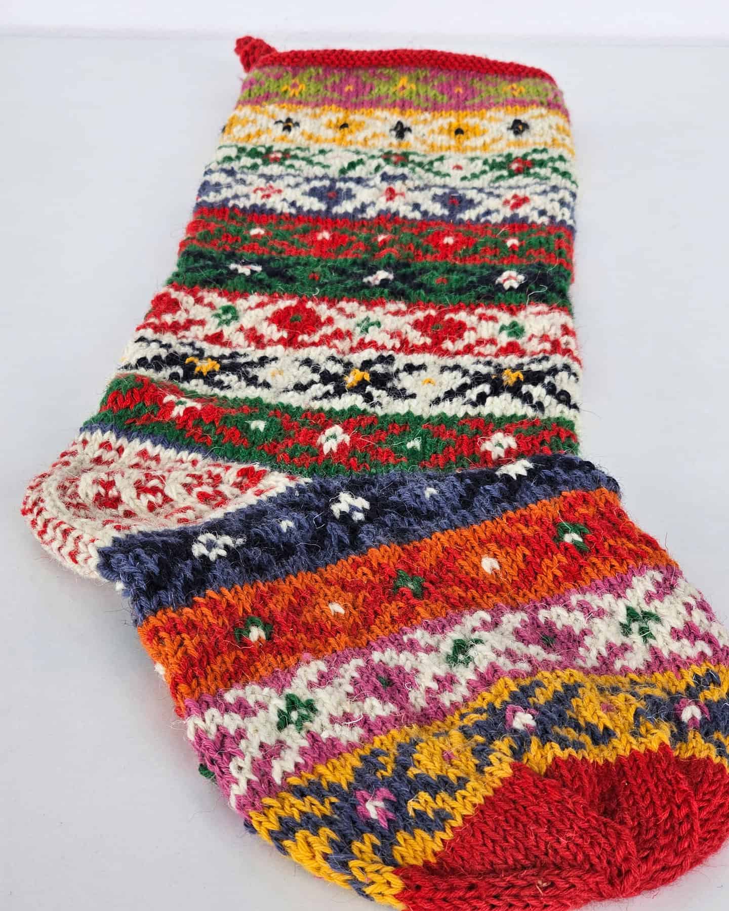 Handmade Fair Trade Christmas stocking featuring vibrant stripes and folk-inspired knit motifs.