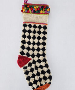 Bold dogtooth patterned stocking in cream and black, adorned with red and green bobbles at heel, toe, and cuff.