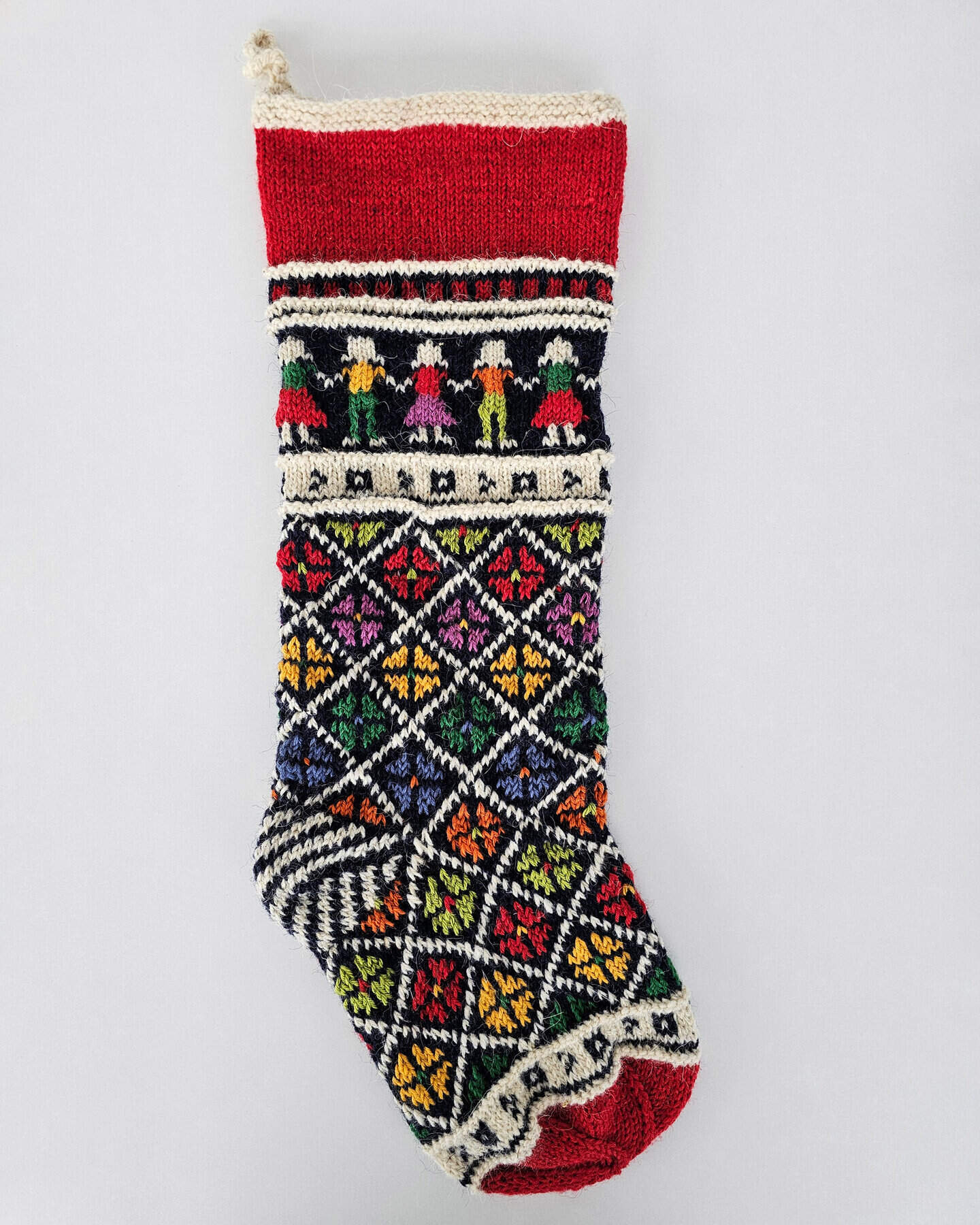 Handcrafted Christmas stocking with a colorful folk art pattern and the option to add a custom name