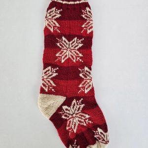 Hand-knitted red Christmas stocking with timeless snowflake pattern