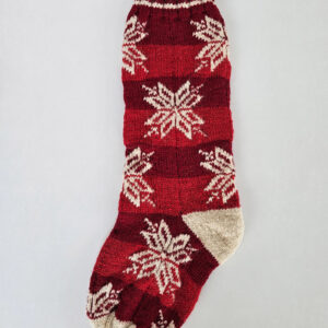 Hand-knitted red Christmas stocking with timeless snowflake pattern