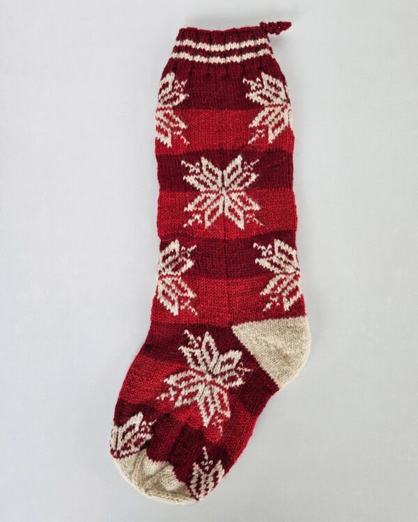 Hand-knitted red Christmas stocking with timeless snowflake pattern