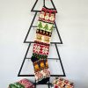 Handmade Christmas stocking with Christmas symbols displayed with holiday decorations and gifts.