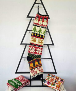 Handmade Christmas stocking with Christmas symbols displayed with holiday decorations and gifts.