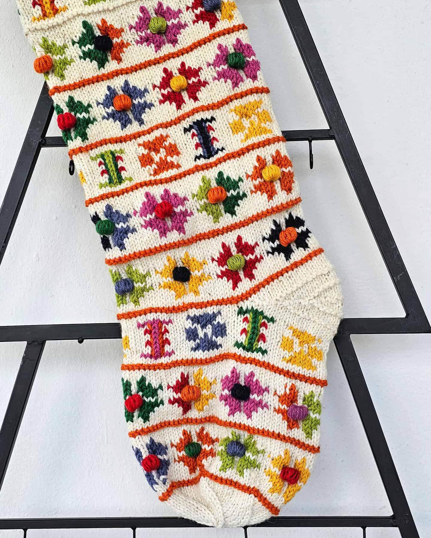 Artisan knit wool holiday tree stocking with festive flower motifs