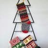 Handmade Christmas stocking with reindeer design displayed with holiday decorations.