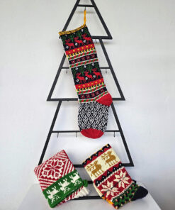 Handmade Christmas stocking with reindeer design displayed with holiday decorations.