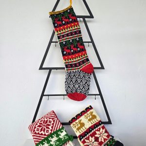 Handmade Christmas stocking with reindeer design displayed with holiday decorations.