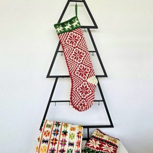 Handmade traditional Christmas stocking displayed with holiday decorations.