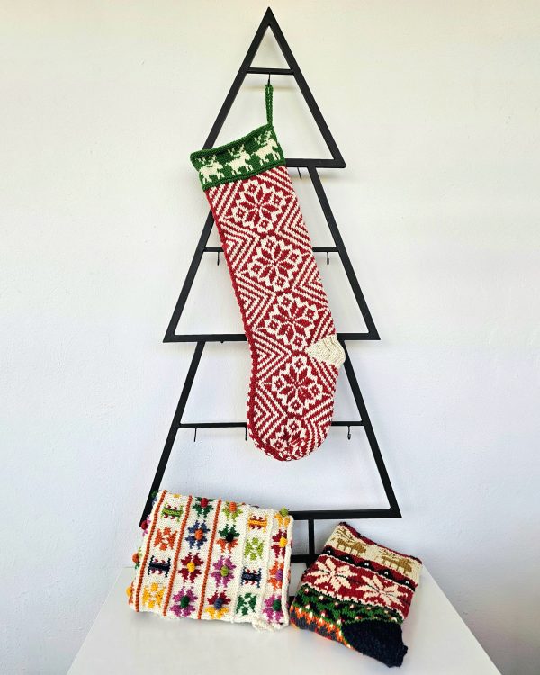 Handmade traditional Christmas stocking displayed with holiday decorations.