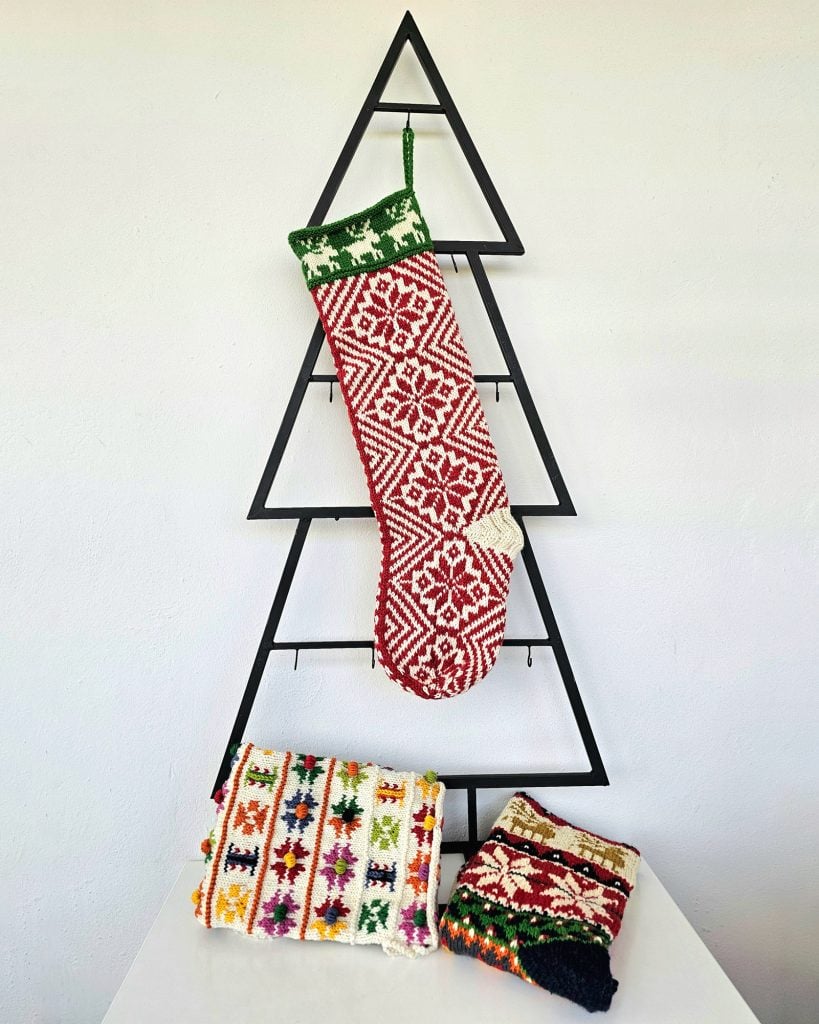 Handmade traditional Christmas stocking displayed with holiday decorations.