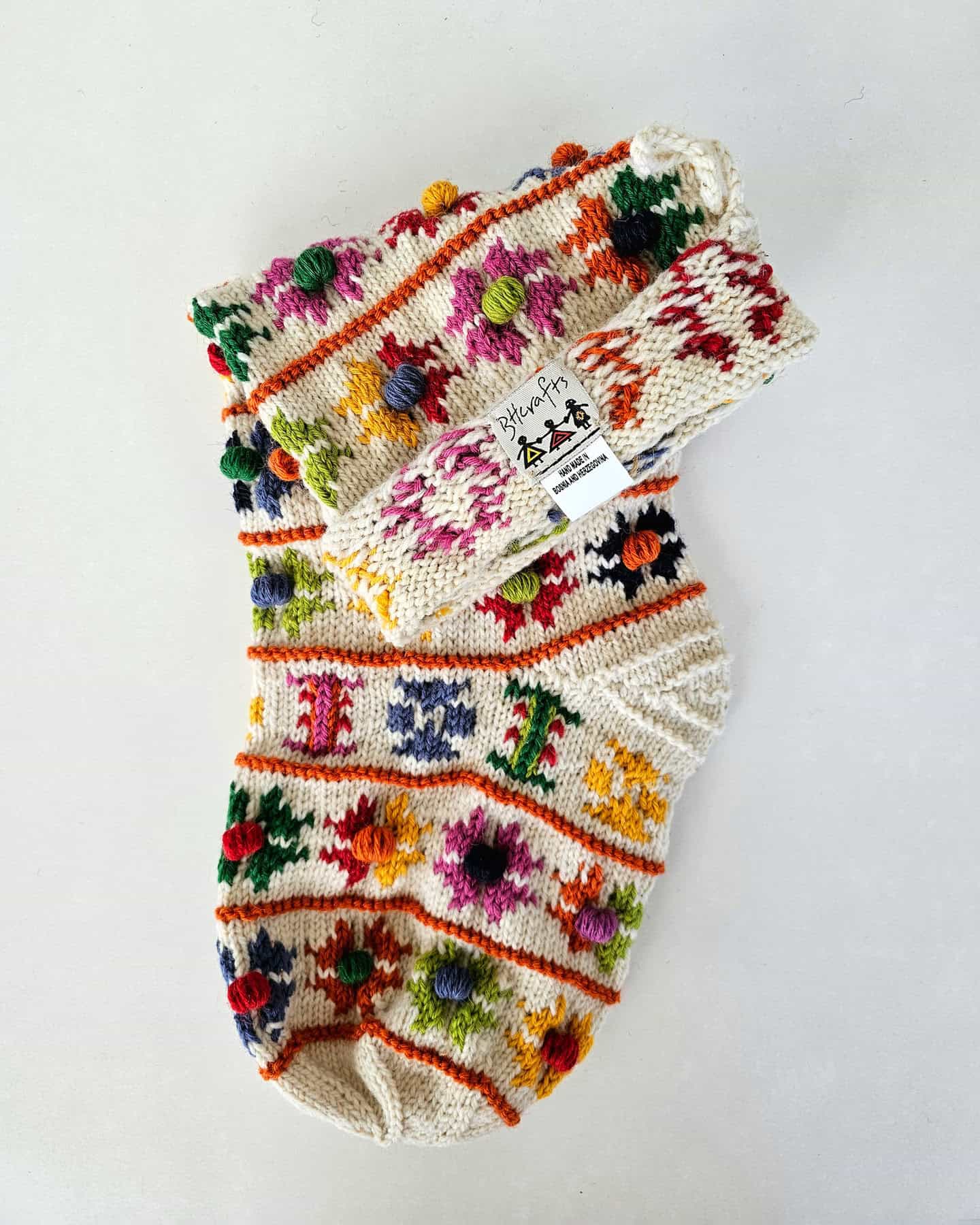 Christmas stocking with pom-poms and flower patterns, product shot
