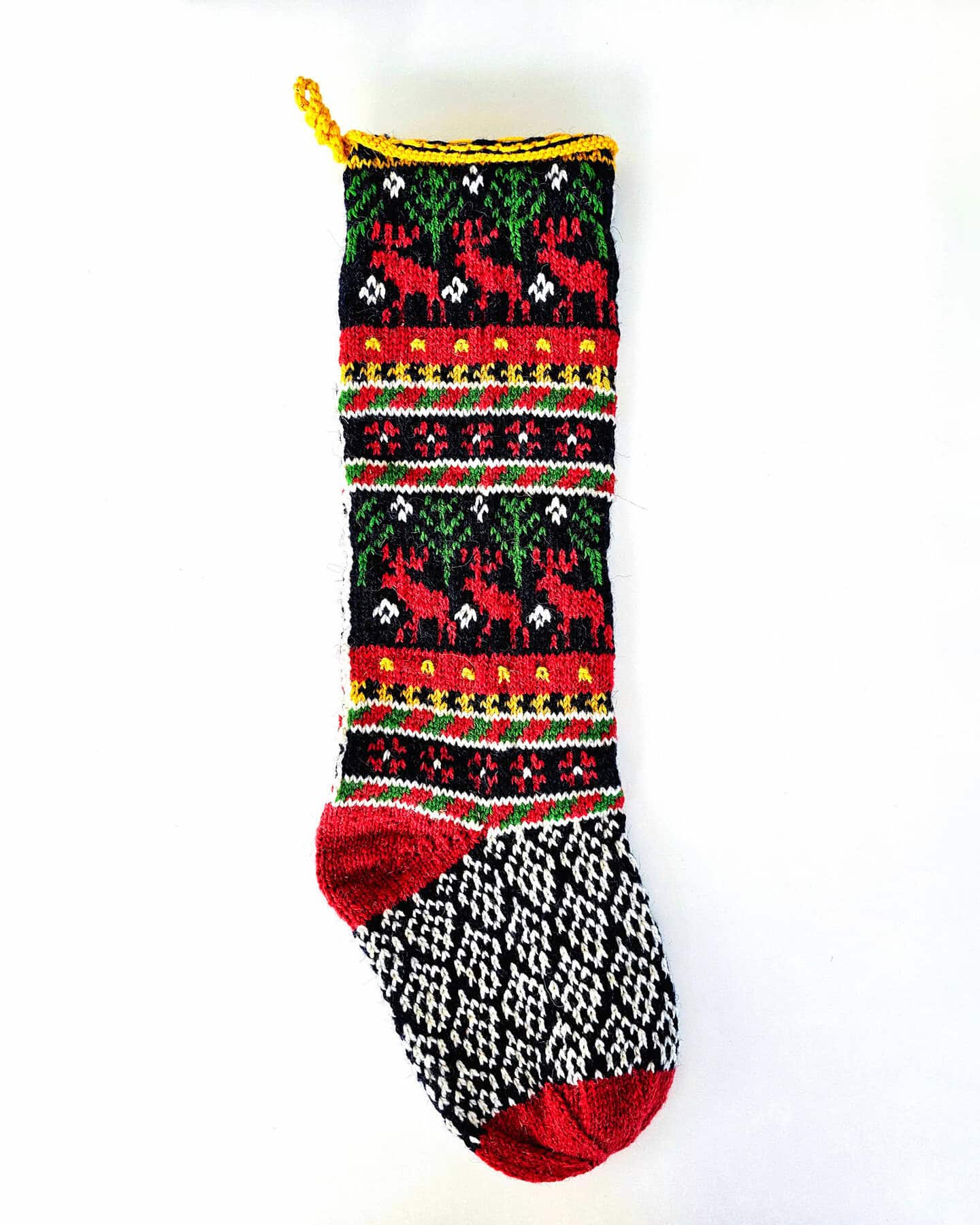 Handmade Christmas stocking featuring reindeer design in traditional holiday colors.
