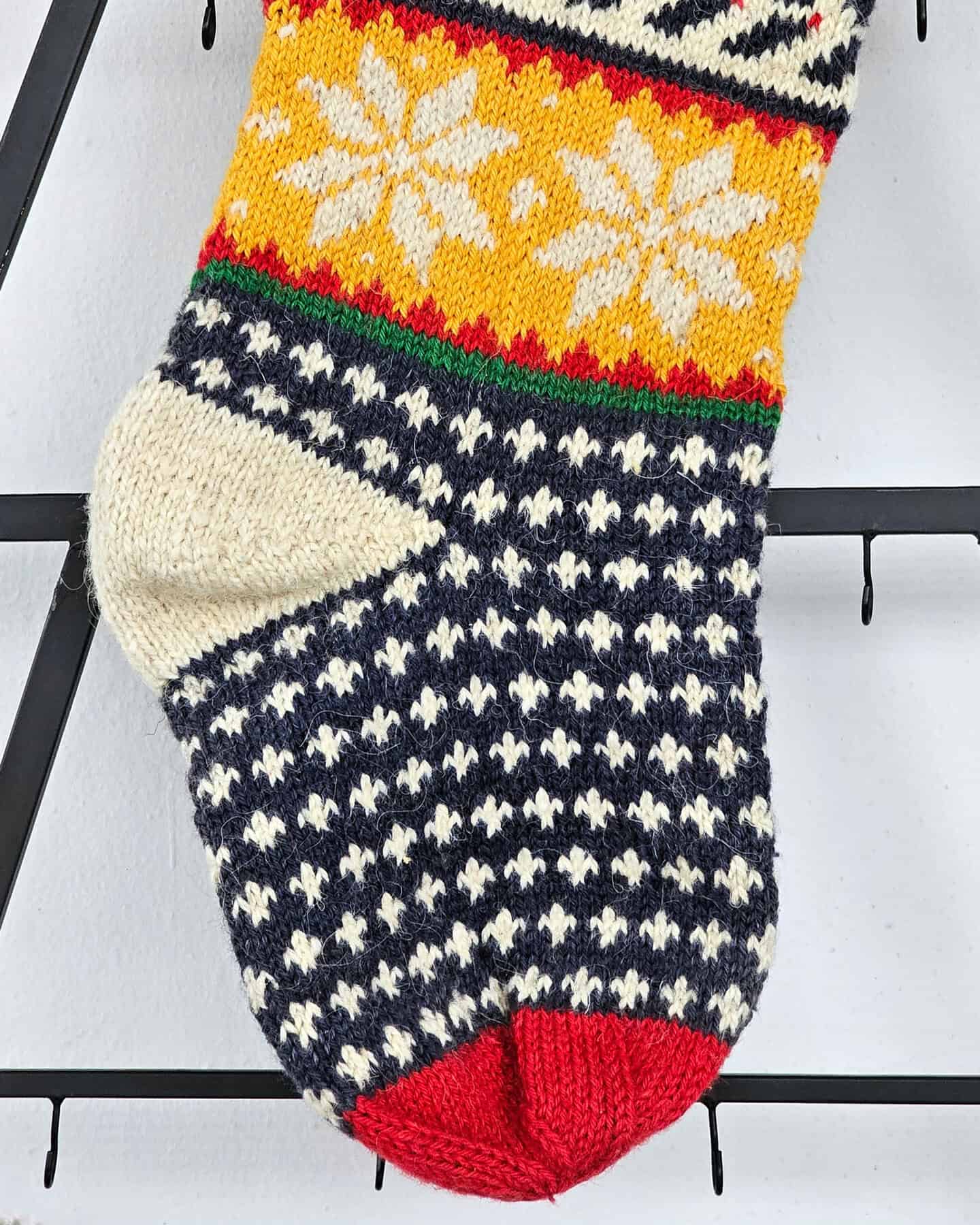 Close-up of Christmas stocking heel showing knitted detail and color pattern.