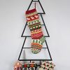 Christmas stocking displayed on a Christmas tree shape with holiday decorations.