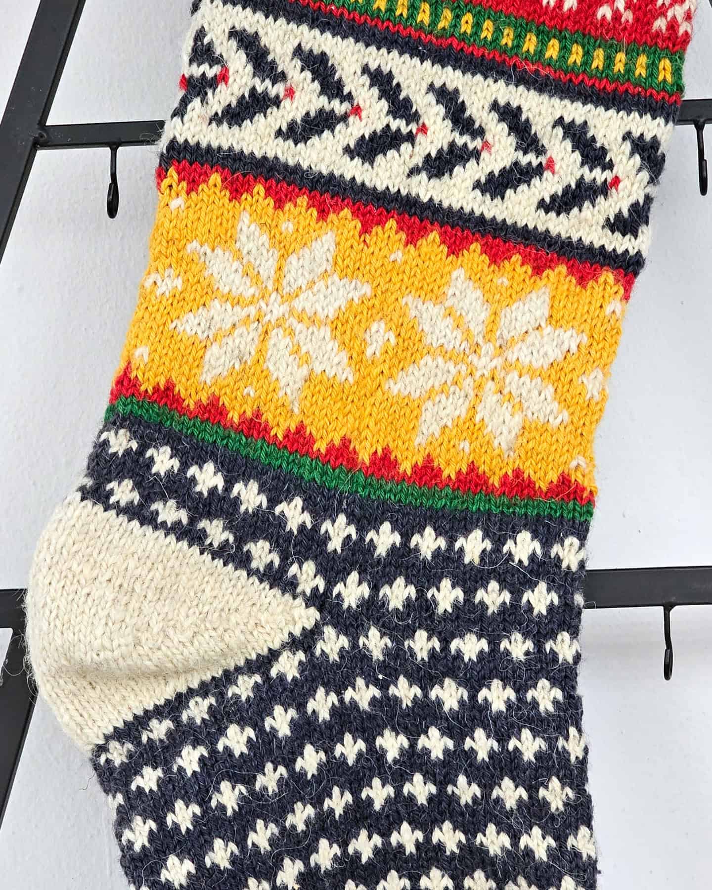 Close-up of hand-knitted snowflake patterns on Christmas stocking.