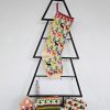 Colorful hand-knitted Christmas stocking featuring festive patterns of reindeer and trees in red, green, white, and beige.