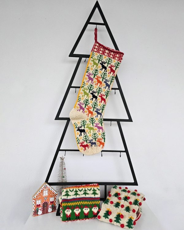 Colorful hand-knitted Christmas stocking featuring festive patterns of reindeer and trees in red, green, white, and beige.