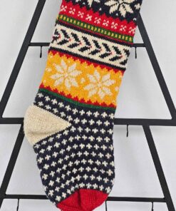 Close-up of hand-knit texture and snowflake pattern on Christmas stocking.