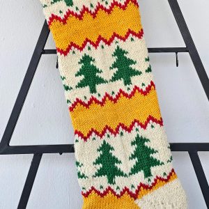 Hand‑knitted Christmas stocking with chevron‑tree pattern in red, cream, and green