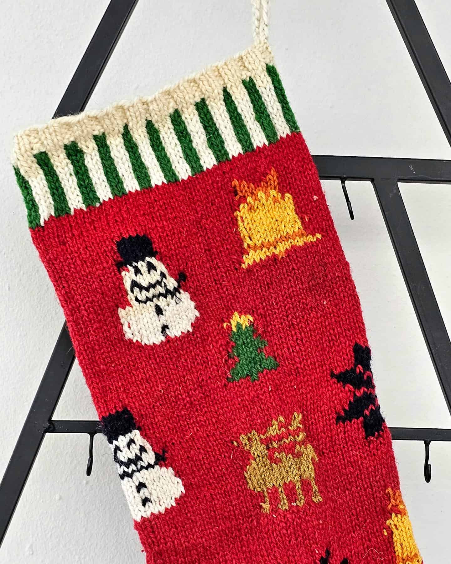 Handmade Christmas stocking with festive red, green, and white knit patterns and holiday motifs