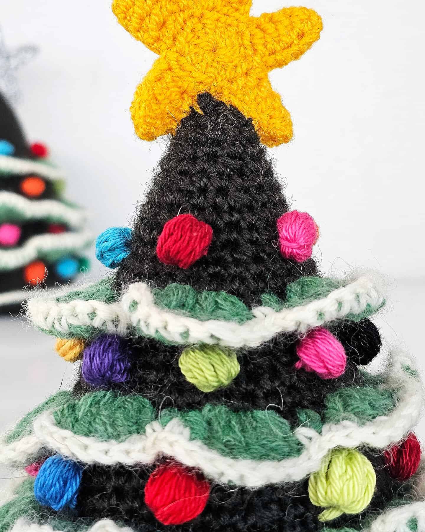 Close-up of fair trade crocheted Christmas tree ornament showcasing multicolor bobble decorations and star topper.