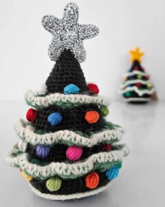 Handmade crochet Christmas tree ornament displayed on a festive tabletop with this eco-friendly holiday décor.