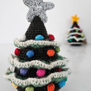 Handmade crochet Christmas tree ornament displayed on a festive tabletop with this eco-friendly holiday décor.