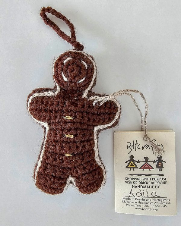 Hand-crocheted gingerbread man Christmas ornament with festive details and hanging loop
