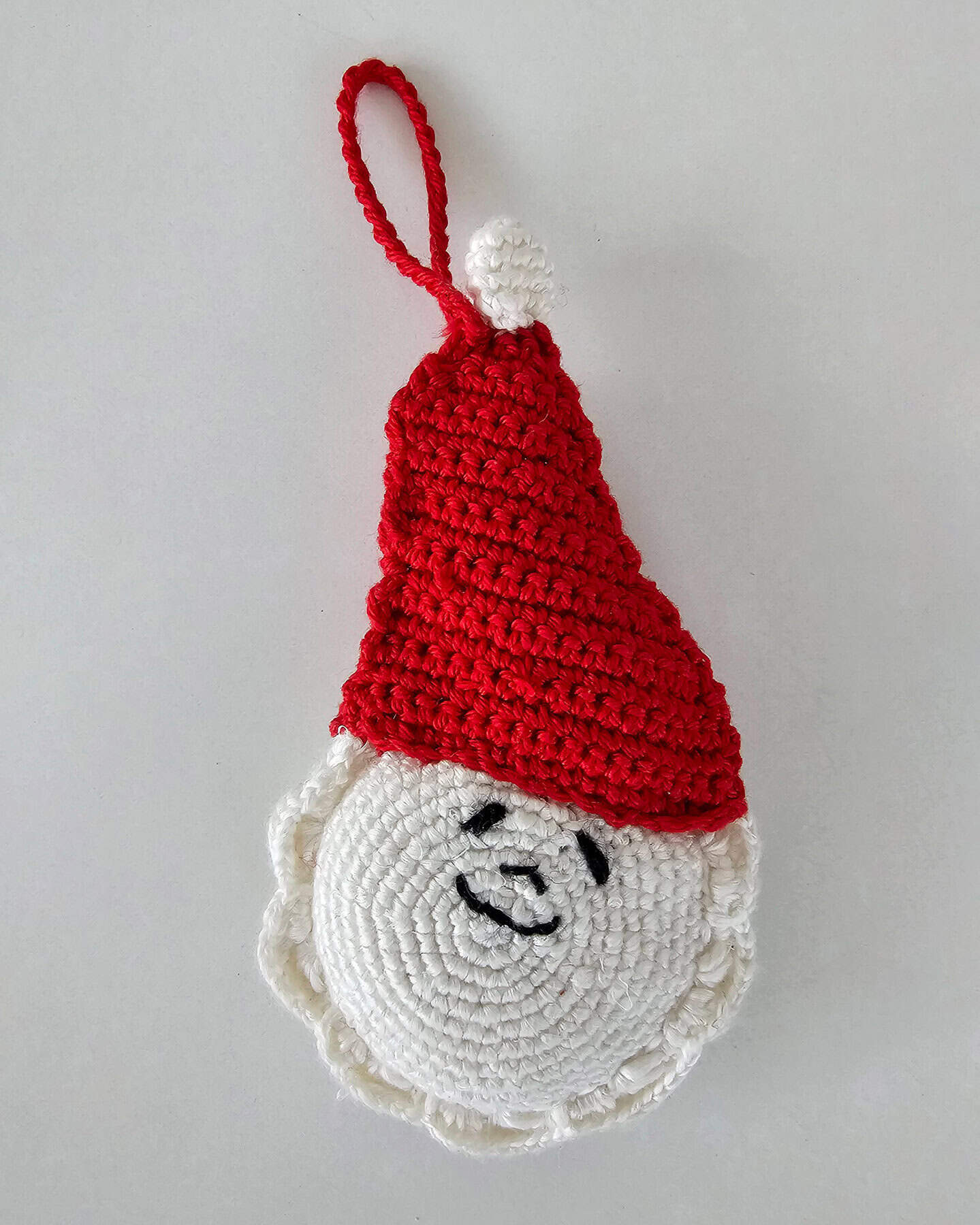 Crochet Santa Claus Christmas Holiday tree decor with red textured hat, white face, smile and hang loop