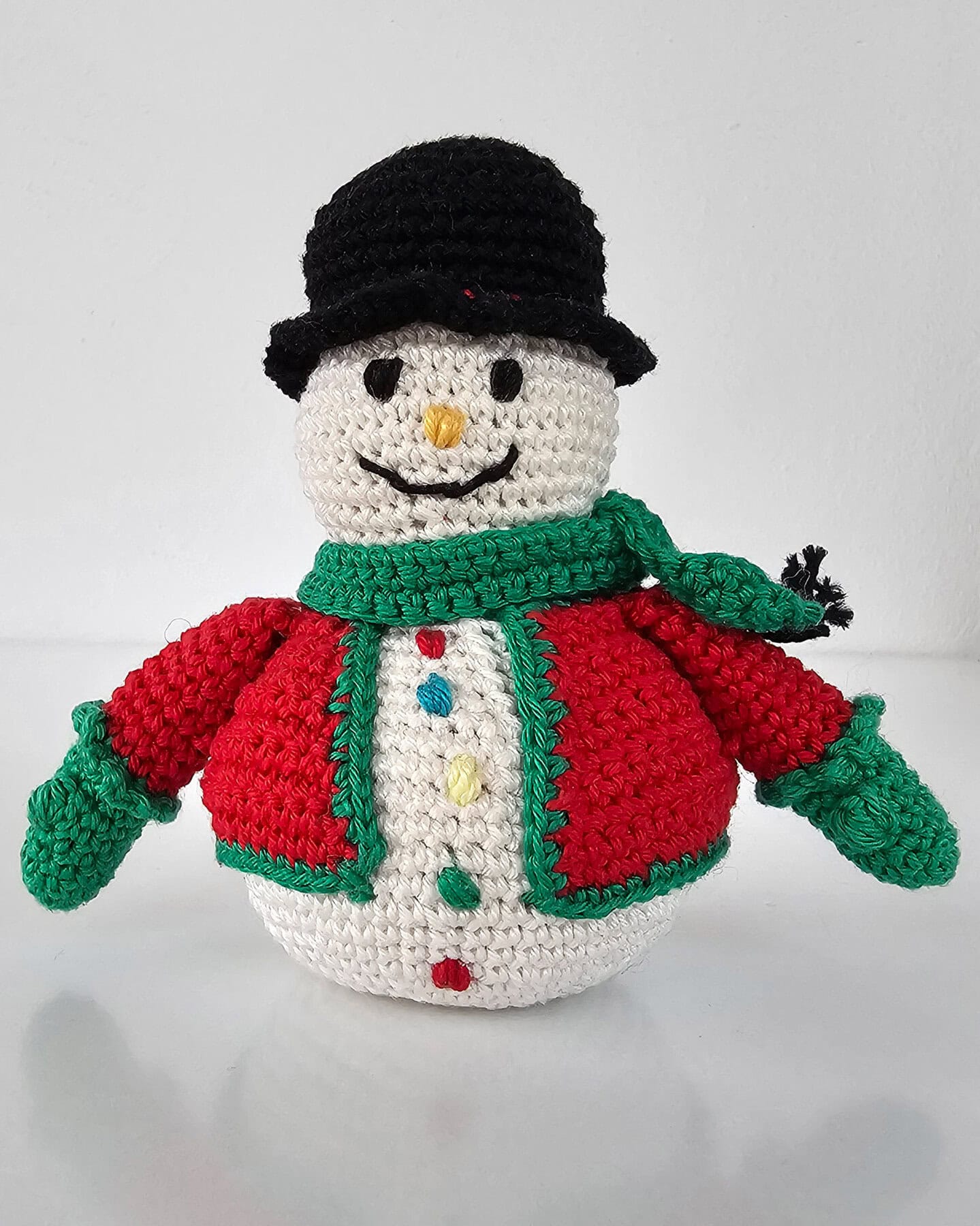 Handmade Crochet Snowman Doll Christmas decoration with red jacket, green scarf, and black hat