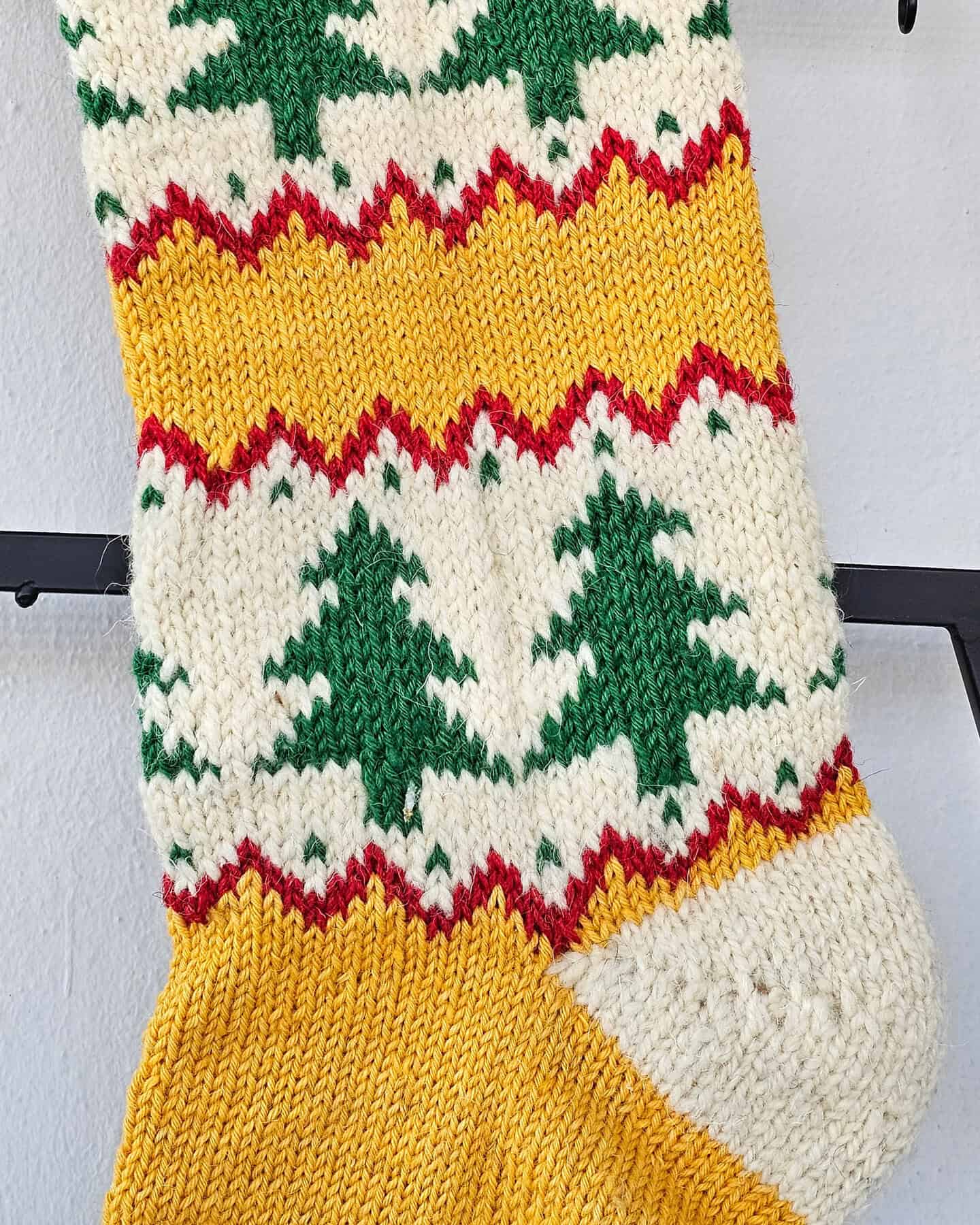 Hand‑knitted ethically produced Christmas stocking in red, cream, and green